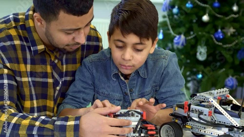 Father and son joyfully explore a toy tracked ATV together