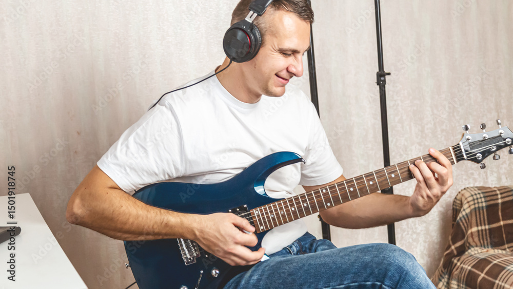 Obraz premium Guitarist. Focused man in headset enjoy creative hobby play electric guitar at home. Man musician practice in playing musical instrument
