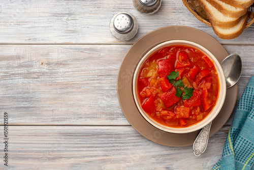 Traditional Hungarian dish lecho or Lecso or Letscho. Stew with peppers, tomatoes and onions in bowl on wooden background.