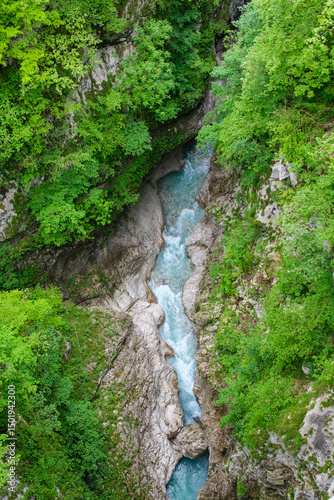 River gorge with turquoise water cascading down steep cliffs lush vegetation and a vibrant natural scene