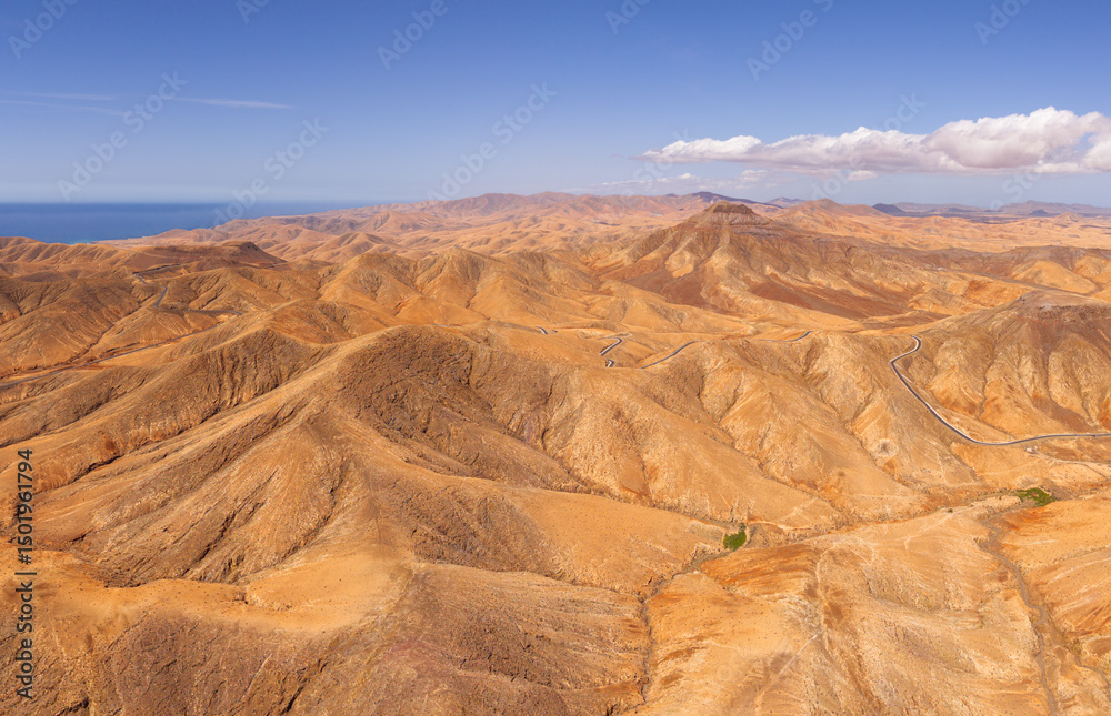 Naklejka premium Dramatic aerial panoramic image of Montana Cardon, the Jandia peninsular and the volcanic mountain landscape of Fuerteventura Canary Islands Spain