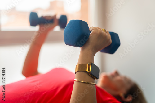 Woman doing strength exercises with small dumbbells to strengthen her arms