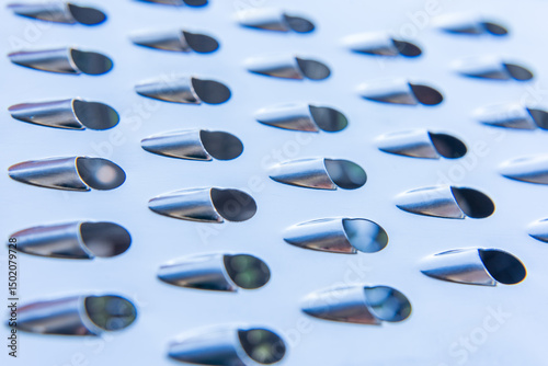 Abstract. Close-up of metal grater with oval-shaped blades. photo