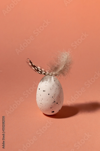 Quail egg with feather. Happy Easter concept. Minimalist composition
