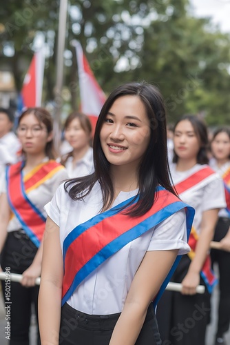 Smiling young asian woman in uniform leading a parade with fellow participants