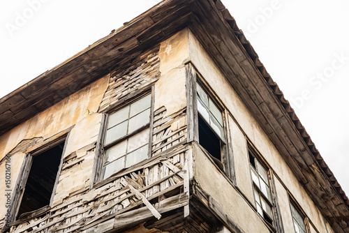 Принти на полотні Abandoned, weathered two-story house with cracked wooden facade and broken windo