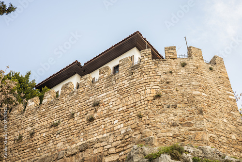 Quadro su tela Historic stone fortress wall with rooftop structure under clear sky