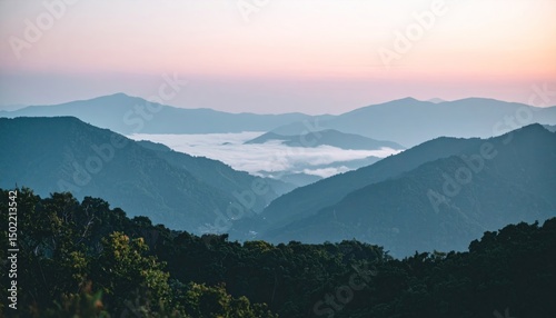 Misty mountain range at sunrise with rolling hills and a hazy valley