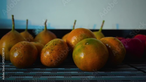 fruit is on the table. Tangerines, apples and passionfruit on the table
