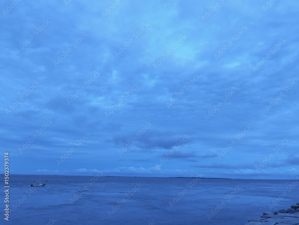 Obraz premium The sky is cloudy and the ocean is calm, Calm ocean waves rolling onto sandy beach under cloudy sky scenic view from above nature landscape seascape coastal scene
