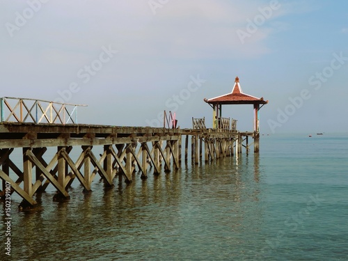 Beautiful sunrise view with wooden pier at Pantai Pasir Putih Situbondo Indonesia, tourism travelling destination 