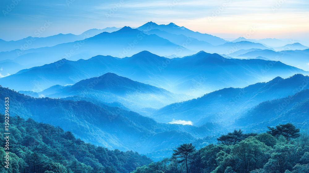 Obraz premium Breathtaking mountain silhouette at dawn, showcasing layers of blue hues and misty valleys, evoking sense of tranquility and wonder