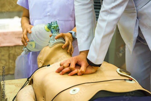 Healthcare professionals practicing cardiopulmonary resuscitation on a dummy, using coordinated chest compressions and artificial ventilation. Essential CPR training