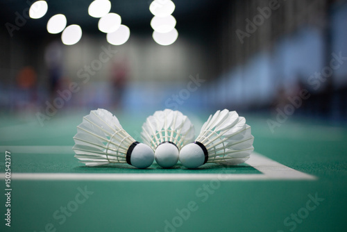 Shuttlecock on green badminton court, badminton competition background