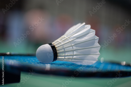 Badminton shuttlecock on badminton racket background in competition field