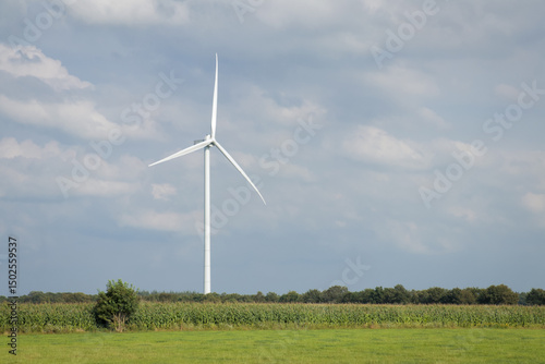 Landscape photo of wind turbine in meadow farming field. Green renewable energy, global warming, climate change, sustainability, farm land concept. 