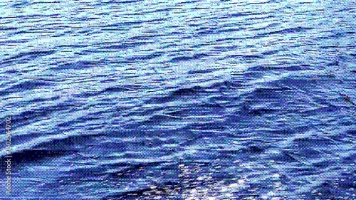 Video of moving water surface with digital dithering effect. Pixelated texture, blue tones, soft splashes. Stylized for creative backgrounds and visual content.
