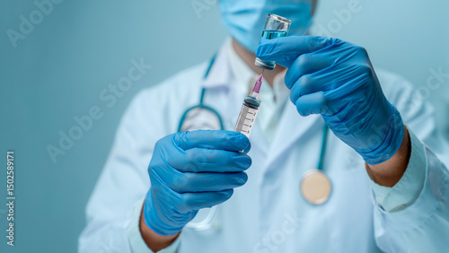 Obraz na płótnie Doctor in blue glove and face mask is filling syringe with vaccine