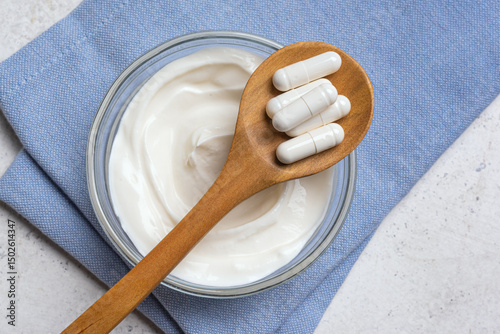 Capsules probiotic and bowl of yogurt