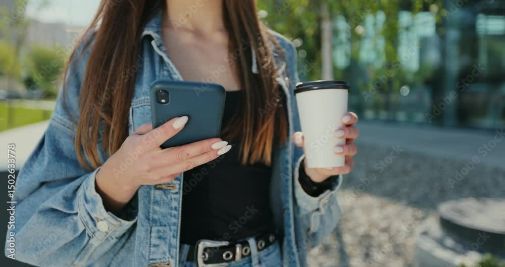 Close up woman using smartphone at street. Beautiful woman using phone with takeaway coffee on street. Communication, online shopping, chat, social networking concept.