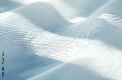 A close-up shot of a smooth, white fabric with subtle folds and light reflecting on its surface
