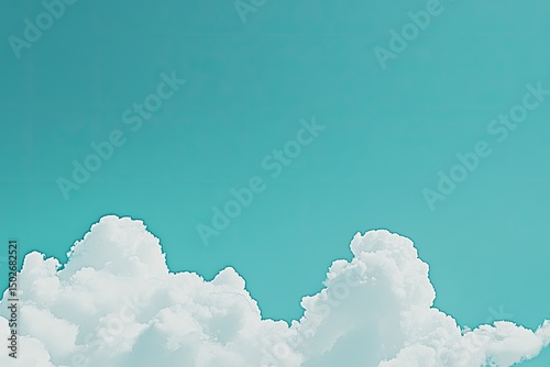 A bright turquoise sky with fluffy white clouds near the bottom of the frame
