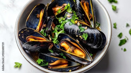Bowl of steamed mussels. the mussels are dark blue in color and have a glossy texture. they are arranged in a circular pattern in the bowl, with some overlapping each other.