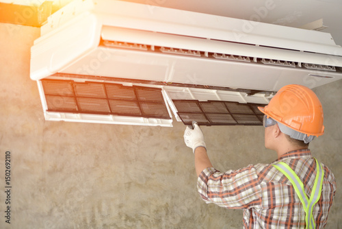 Smiling technician installing air conditioner indoors