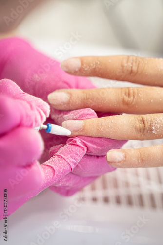 Girl is at a beauty salon. They do her nails, removing the old gel polish. Her nails are clean now, ready for new manicure. Lifestyle concept.