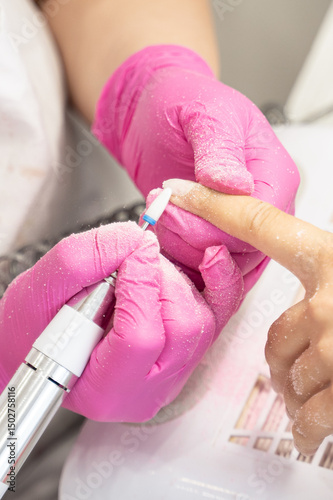 Girl is at a beauty salon. They do her nails, removing the old gel polish. Her nails are clean now, ready for new manicure. Lifestyle concept.