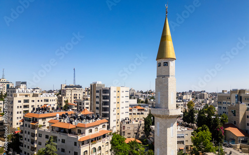 Golden minaret in downtown Ramallah, Palestine, framed against a deep blue sky