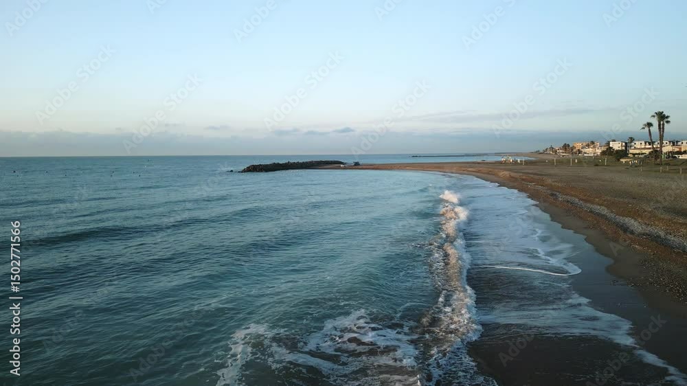 Drone flight over the city embankment along the sea and the beach. Dawn lighting front to the beach flight