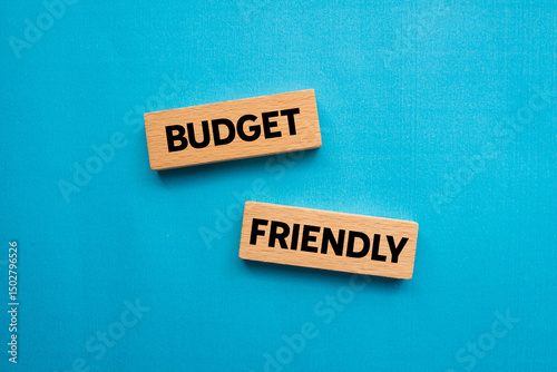 Budget friendly message written on wooden blocks on blue background. Conceptual budget friendly symbol. Copy space. photo