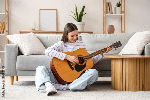 Young woman playing guitar ...