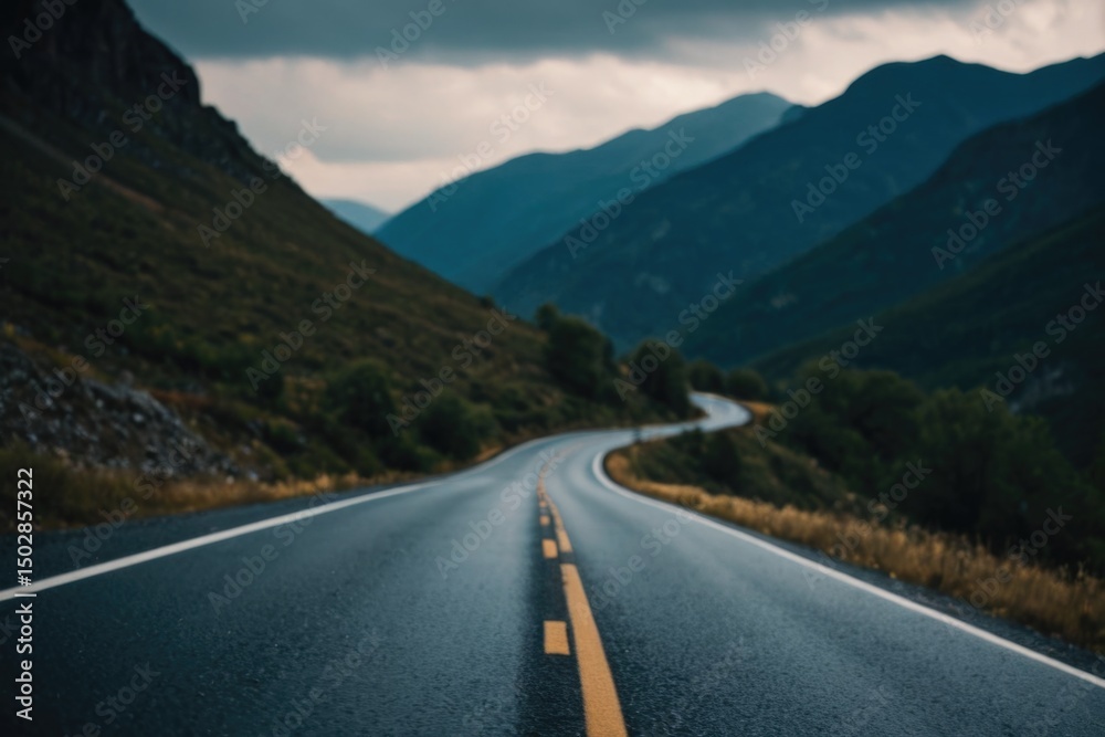 Fototapeta premium A long stretch of empty road winding through mountains