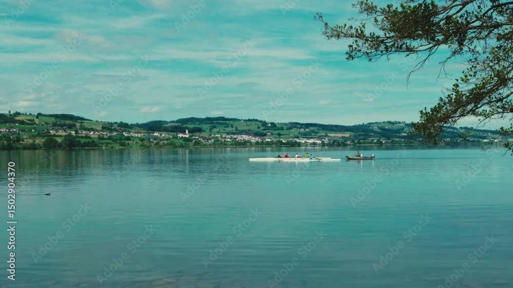 Ruhig gleitet das Ruderboot über den See, jeder Schlag durchschneidet sanft das Wasser. Umgeben von Stille, Natur und Weite wird das Rudern zum meditativen Erlebnis inmitten der Landschaft.