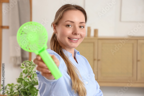 Young woman with mini fan a...