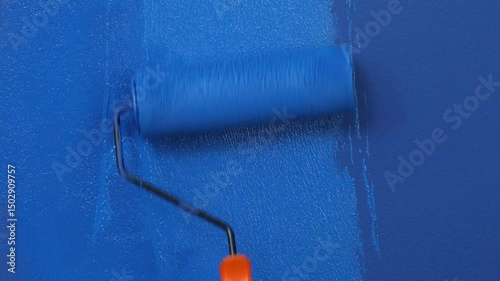 Roller Brush Painting, Worker painting on surface wall Painting apartment, renovating with blue color paint. Leave empty copy space white to write descriptive text beside.