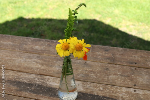 A bouquet of flowers stands in a glass vase.
