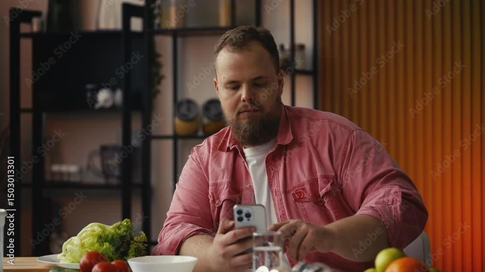 Plus-size man using dieting app on phone, calculating calories of food products