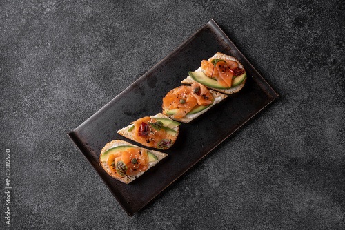 Delight in an array of gourmet dishes and beverages presented on a sleek black plate, showcasing the artistry of contemporary cuisine at a vibrant restaurant