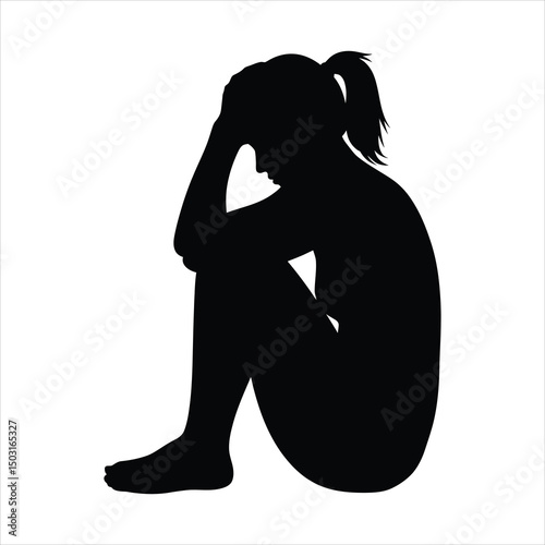 Silhouette of a person sitting depressed with head in hands