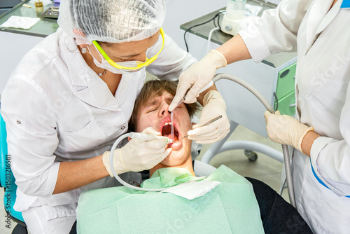 Teenager undergoes dental procedures in a bright clinic with professionals attending to oral health needs