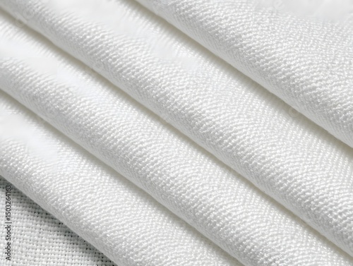 Textile Serenity: The image reveals a close-up of folded white fabric, with the folds adding depth and dimension, revealing the fine details and texture of the material