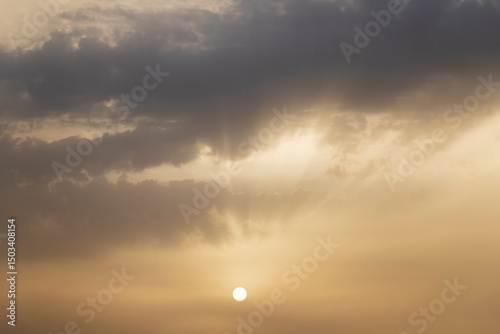 Dramatic clouds and sun with rays in the sky