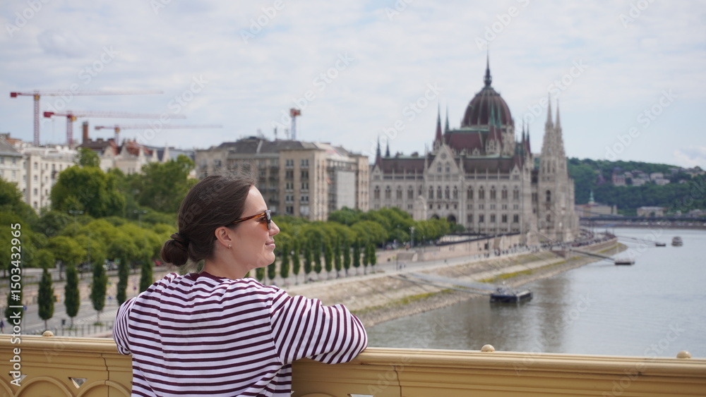 Obraz premium young woman in sunglasses on hungarian parliament background