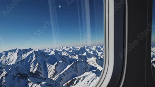 Aerial journey above majestic snowcapped mountain peaks viewed through airplane window