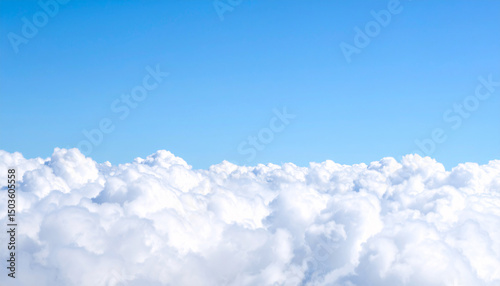 Skyward Serenity: Above a fluffy bed of clouds, a vast expanse of pure blue stretches out, capturing a moment of peace and limitless freedom.