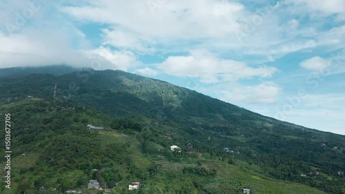 Drone Shot of Mountain Terrain with Remote Tower in Green Landscape


