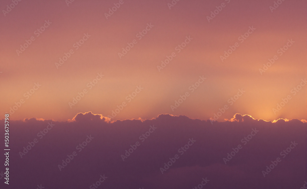 Fototapeta premium Golden sunset over a serene landscape, warm light through clouds, orange and purple hues blending in harmony 